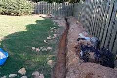 How do you dig a small trench by hand?